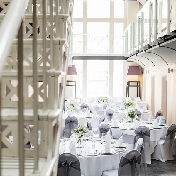 A room adorned with tables draped in pristine white linens.