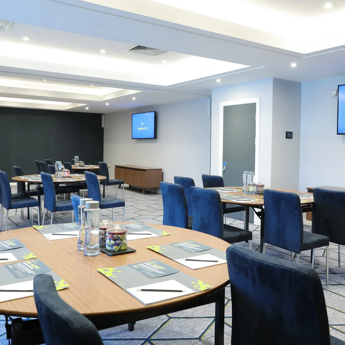 Conference room featuring tables, chairs, and a flat-screen TV.