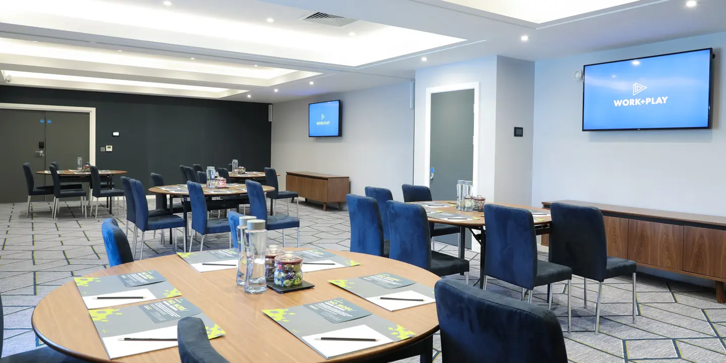 Conference room featuring tables, chairs, and a flat-screen TV.