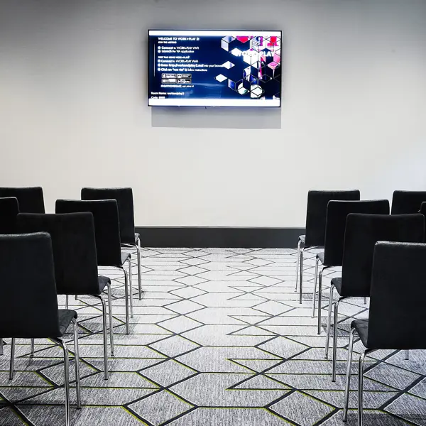 A room furnished with chairs and a flat-screen TV.