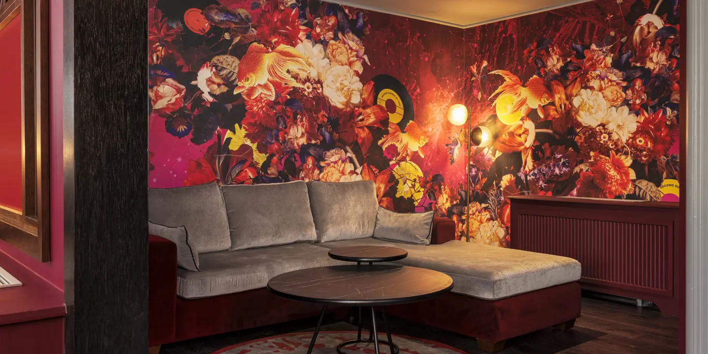 A spacious room featuring a comfortable sofa, coffee table, and radiator.