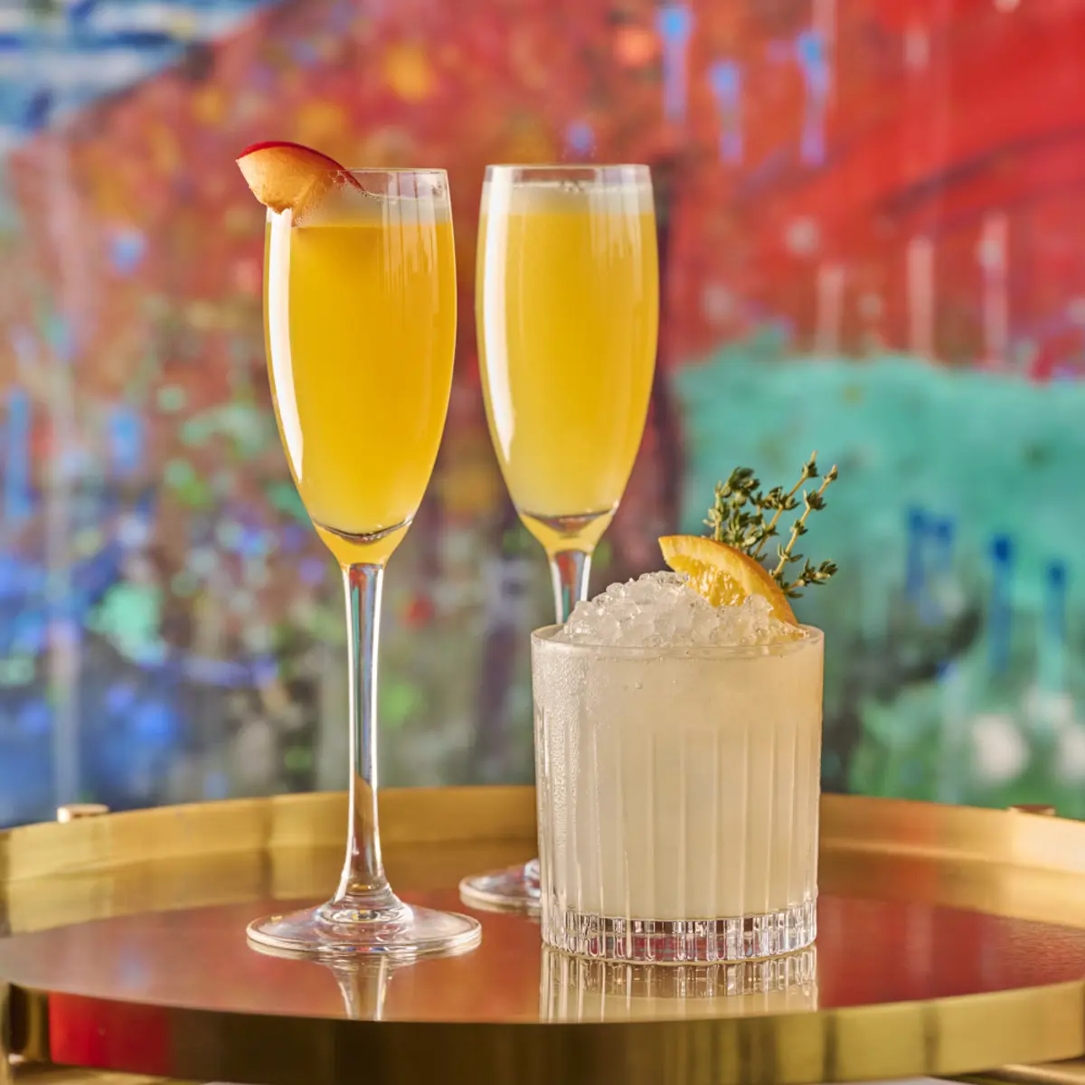 Two garnished cocktails on a marble table