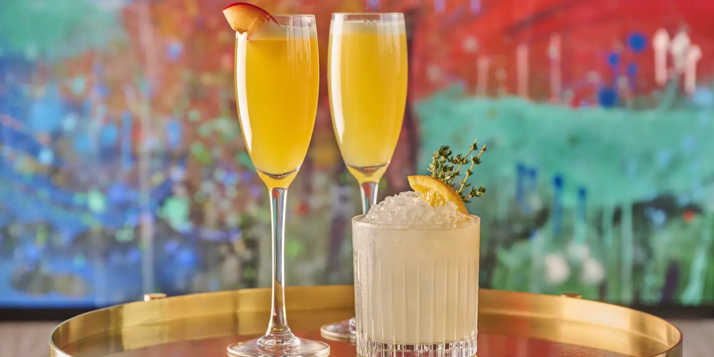 Two garnished cocktails on a marble table