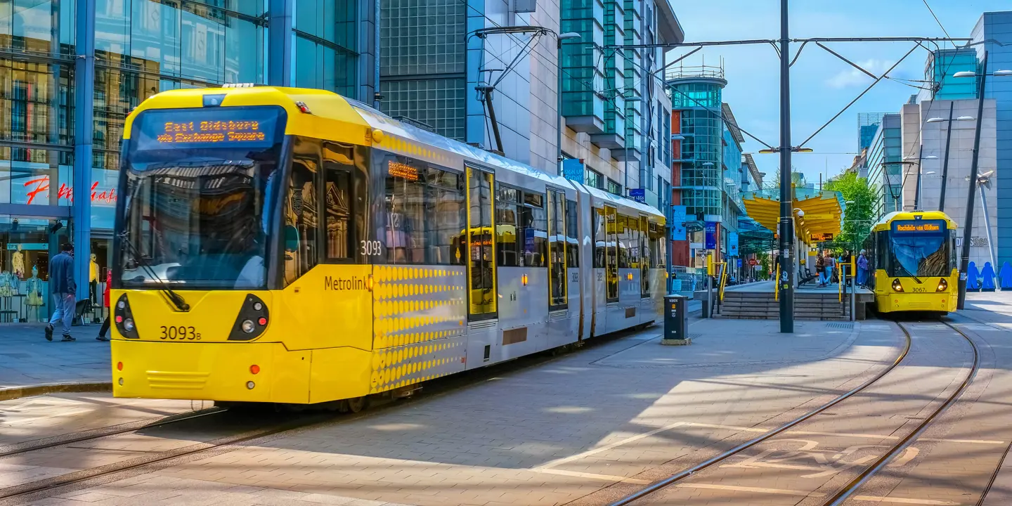 A yellow and white bus on a city street.