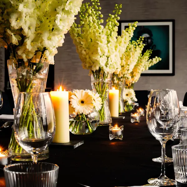 Table set for a formal dinner with candles and flowers.