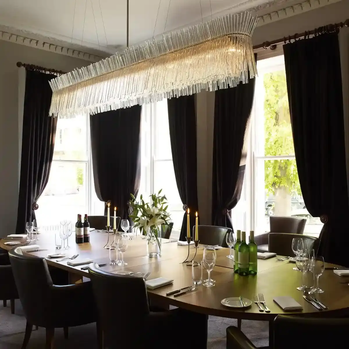 Dining room table with a hanging chandelier above.