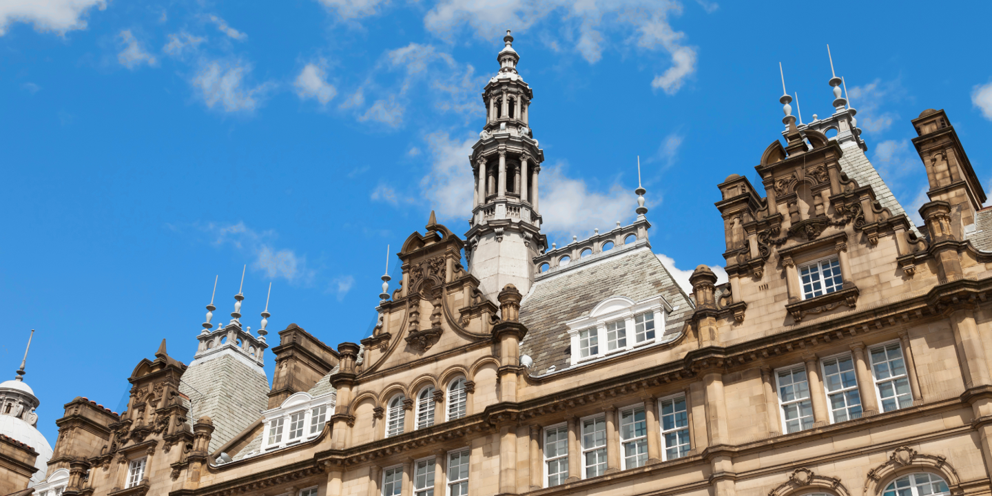 An imposing building featuring a clock tower atop.