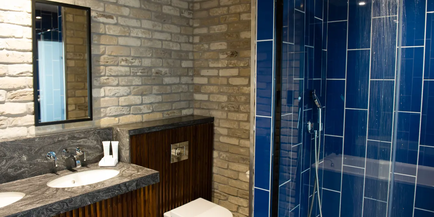 Bathroom featuring a toilet, sink, and shower.