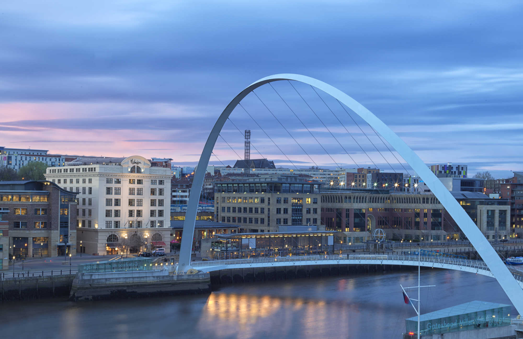 A bridge spanning a body of water with buildings in the background.