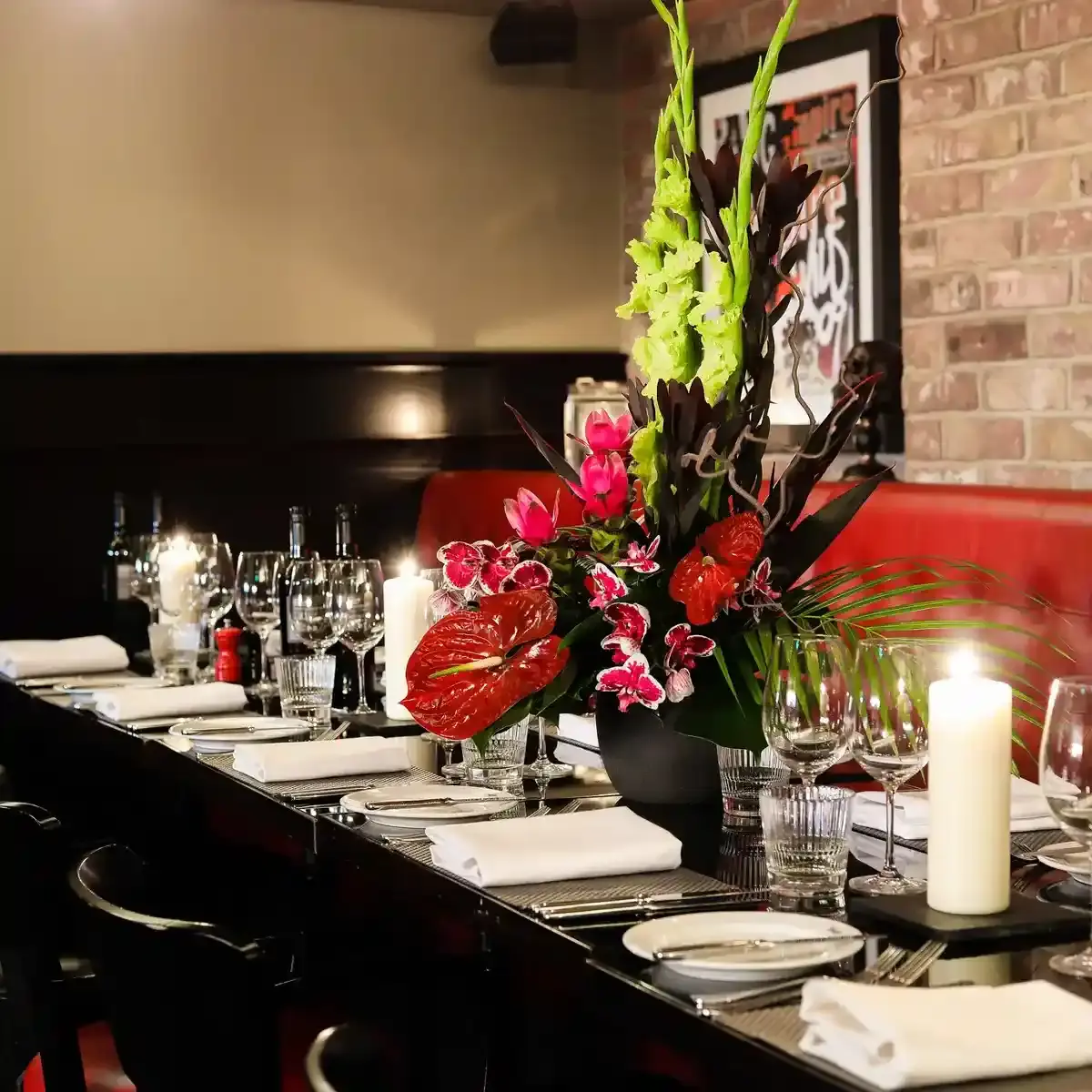 A table adorned with a vase filled with flowers and accompanied by flickering candles.