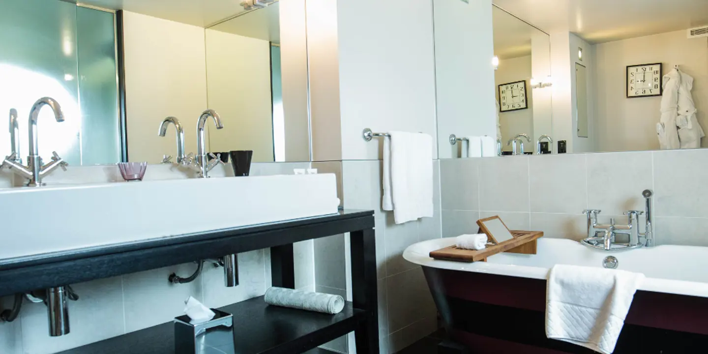 Bathroom featuring a bathtub, sink, and mirror.