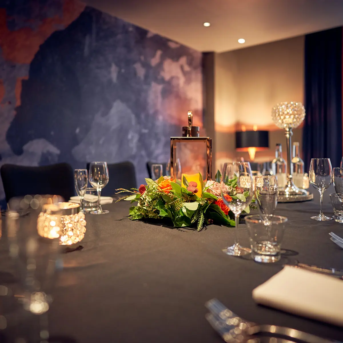 Table set for a formal dinner with candles and flowers.