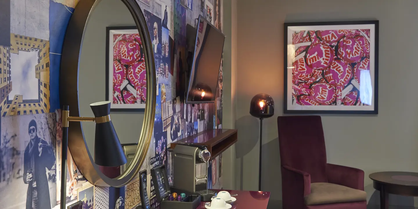 An elegantly furnished room featuring a vibrant red table and a sleek mirror.