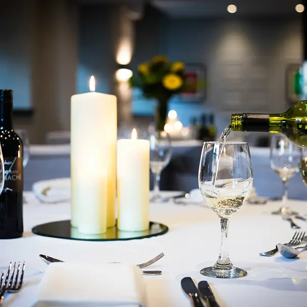 A beautifully arranged table adorned with elegant wine glasses and a flickering candle.