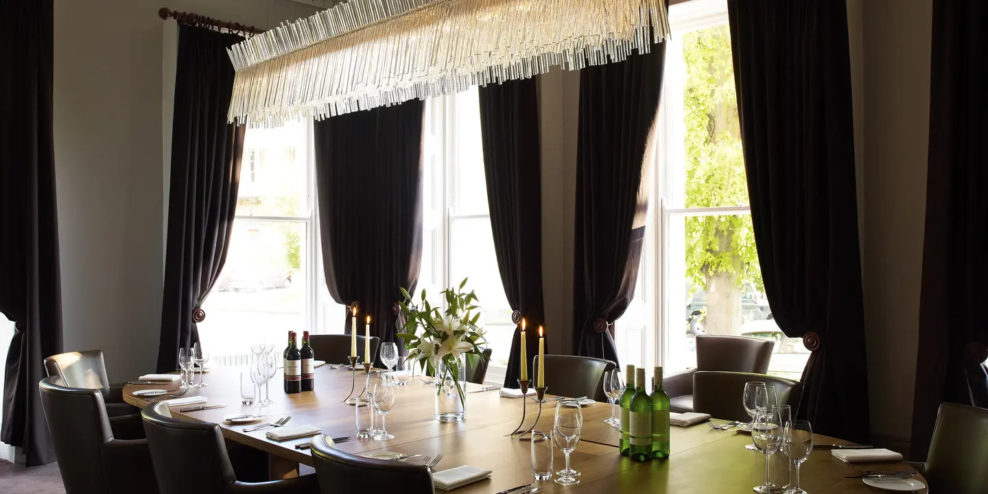 A dining room featuring a table, chairs, and an elegant chandelier.