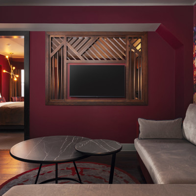 A spacious room featuring a comfortable bed, couch, coffee table and wall-mounted TV