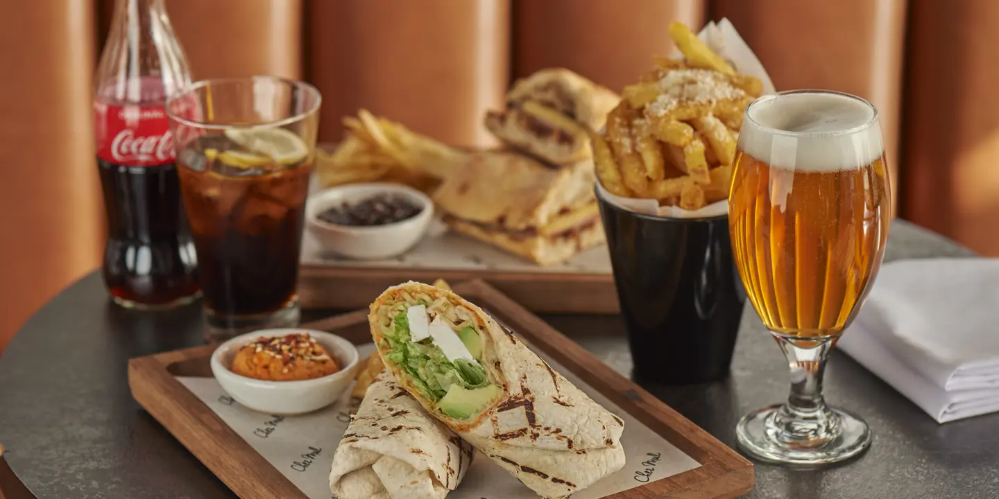 Table adorned with two wraps and a range of drinks.