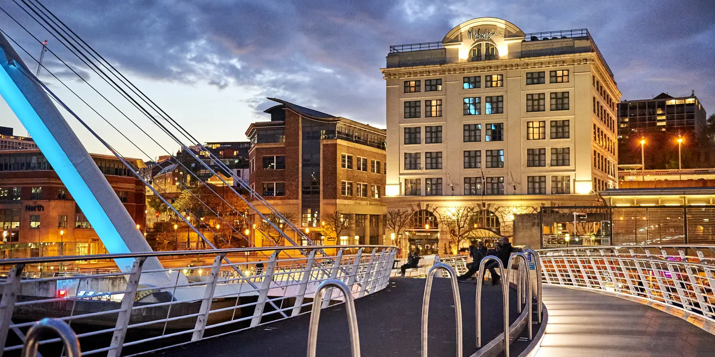 Suspension bridge with buildings at night