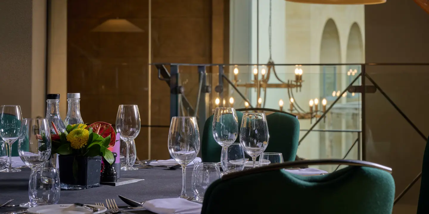 A table adorned with a vase filled with flowers and accompanied by flickering candles.