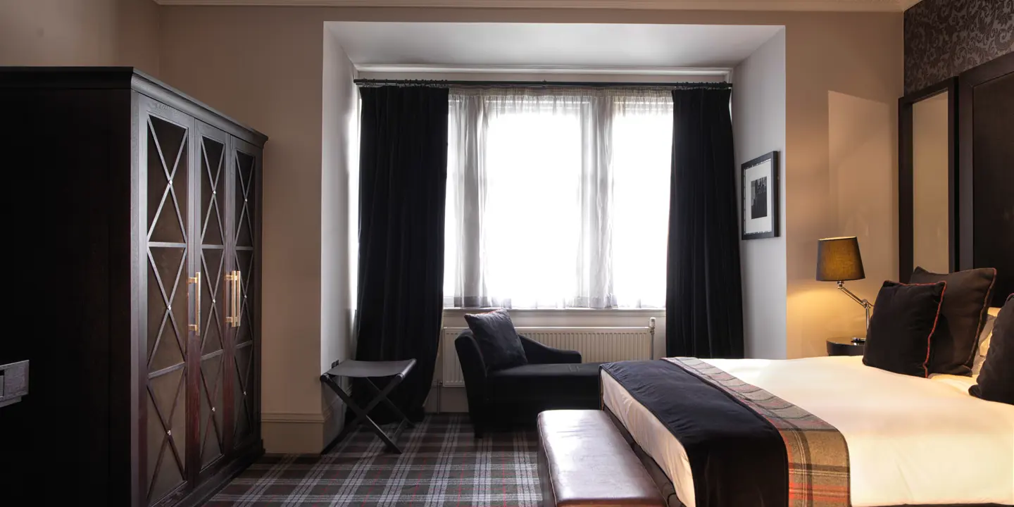 Bedroom with large bed and armchair.