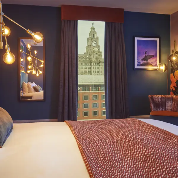 Spacious hotel room featuring a king-sized bed and panoramic city view.