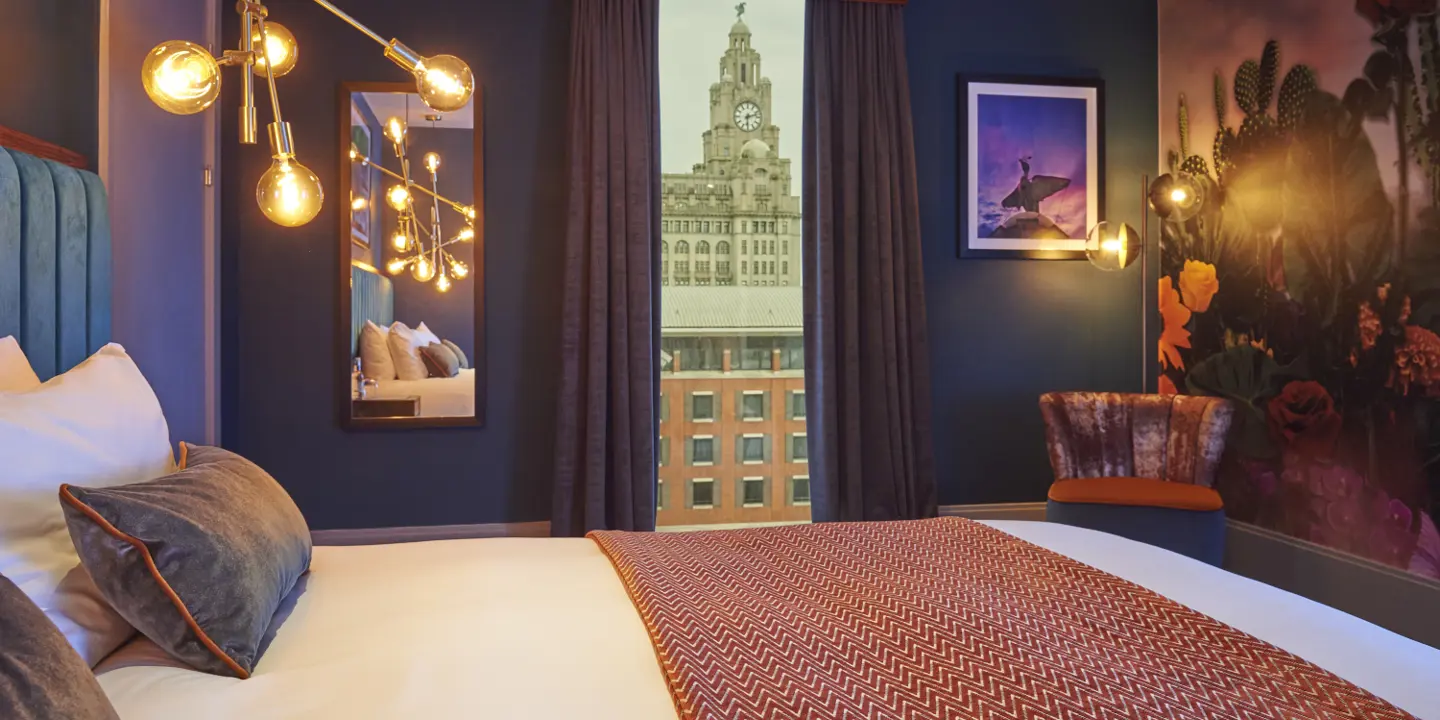 Spacious hotel room featuring a king-sized bed and panoramic city view.