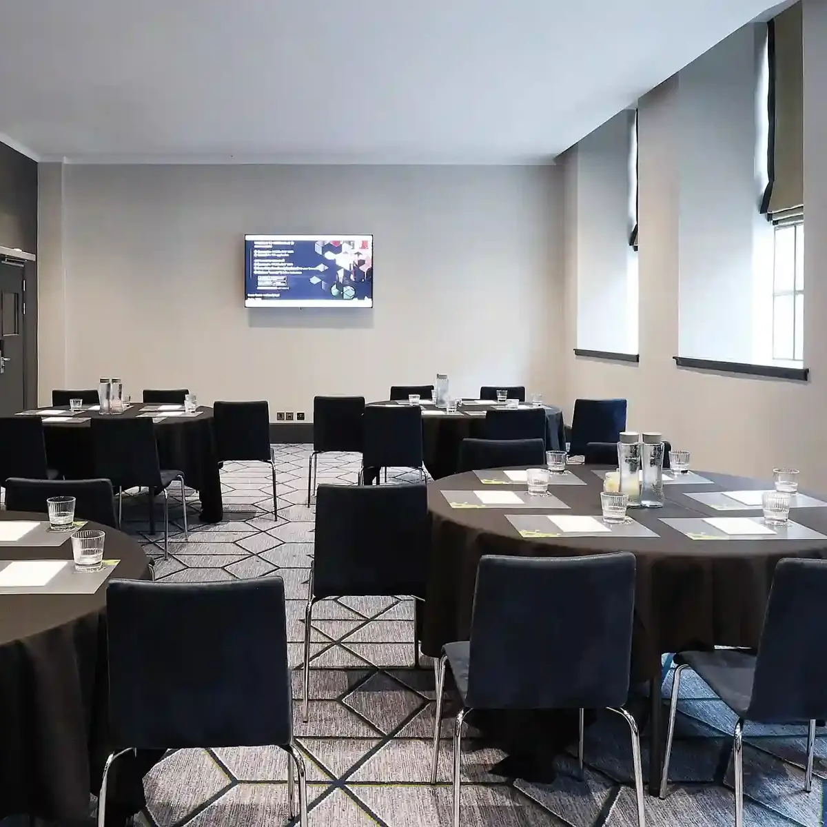 Conference room with neatly arranged tables and chairs.