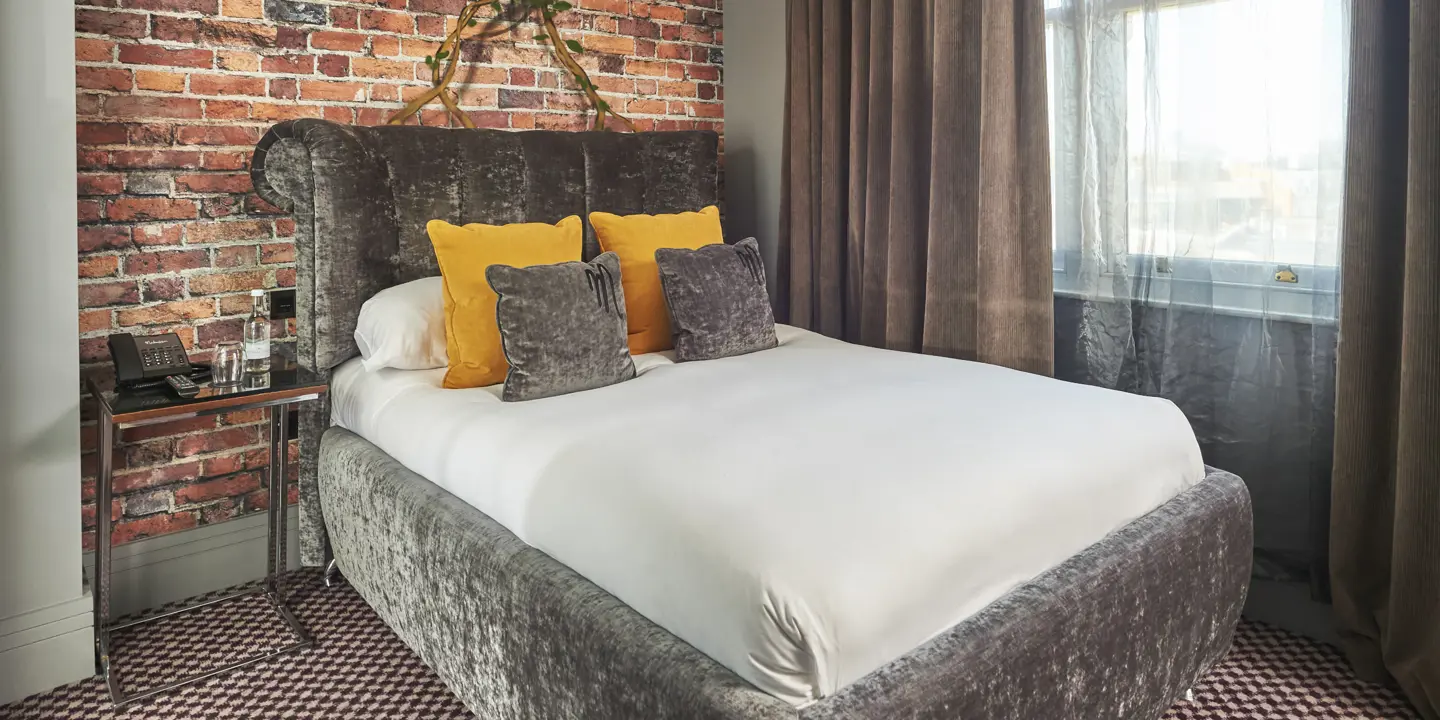 Bedroom featuring a brick wall and a bed.