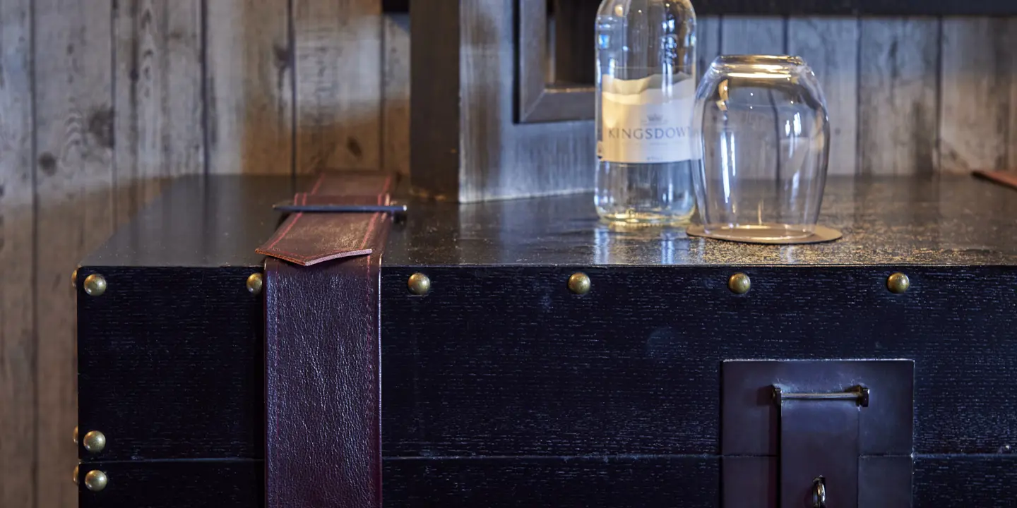 A water glass on a stylish chest.