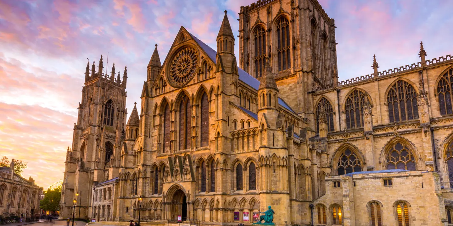 A grand cathedral featuring a prominent clock on its façade.