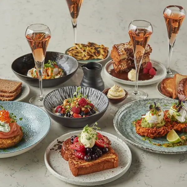 A table adorned with plates of delectable cuisine and elegant champagne glasses.