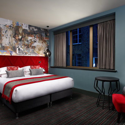 Bedroom featuring a red headboard and chair.