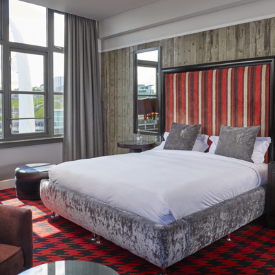 A bed featuring a headboard with red and white stripes.