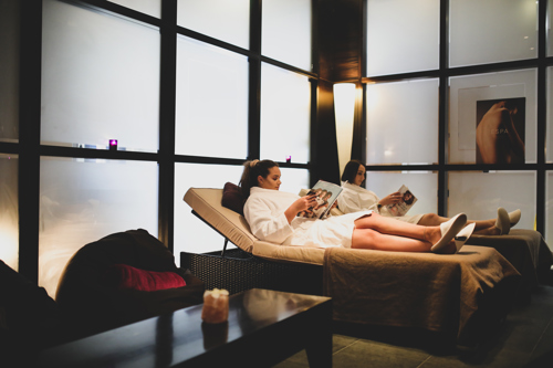 Two women reading magazines in a spa room