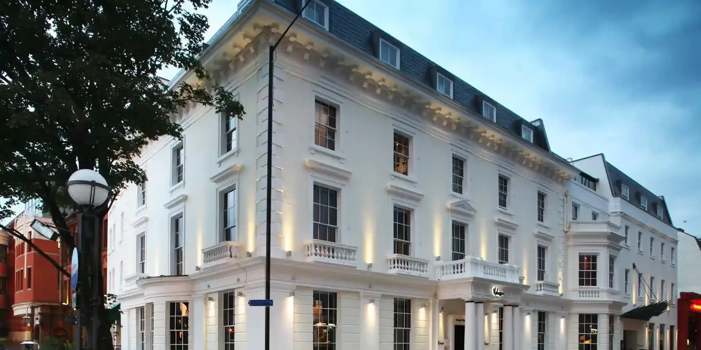 Corner street view of a spacious white building.