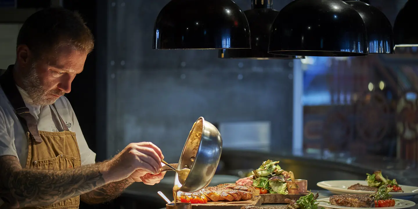 A man preparing food in a restaurant kitchen.