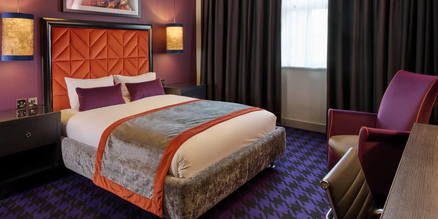 An elegantly designed bed with two plush pillows and an elegant headboard.