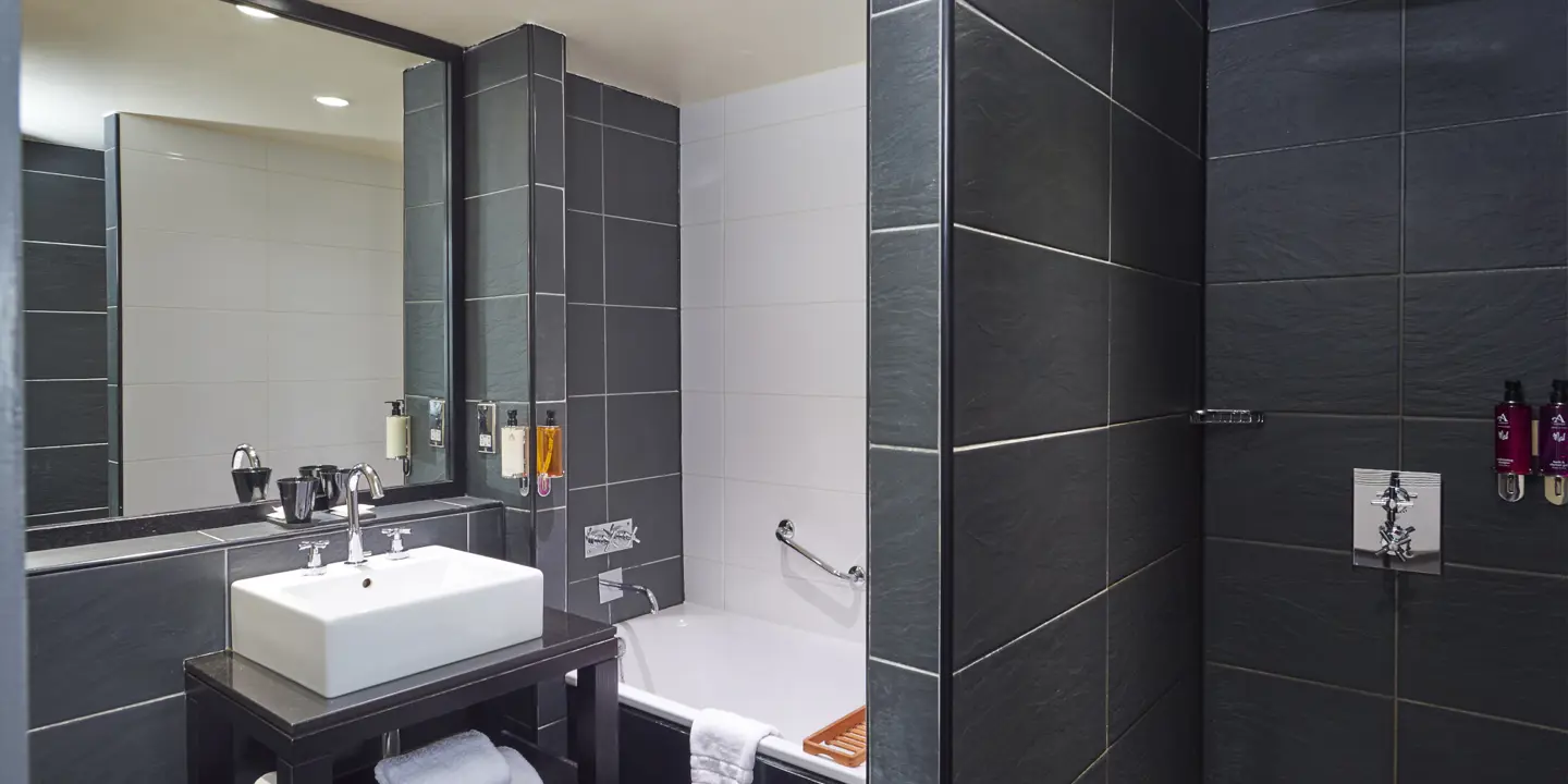 A bathroom featuring a shower, bathtub, and sink.