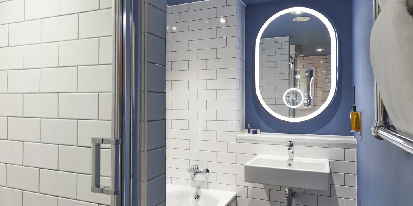 Blue-walled bathroom with white tile.