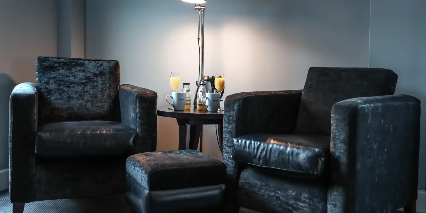 Two chairs and a table in a well-furnished living room.