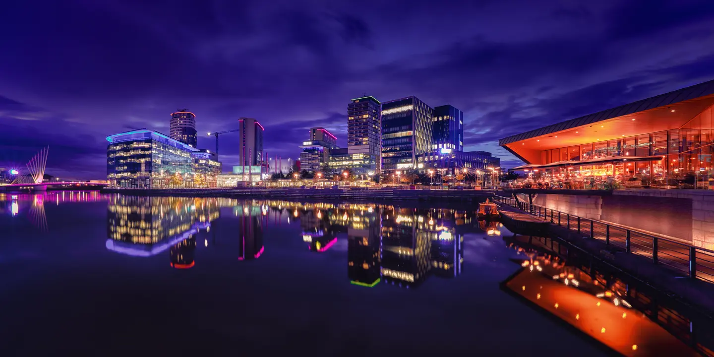 Nighttime view of a city alongside a vast body of water.