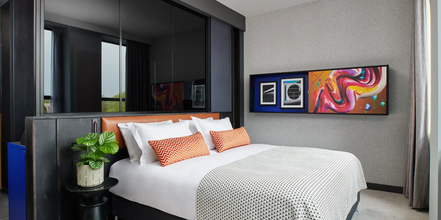 Bedroom featuring a bed adorned with orange cushions.