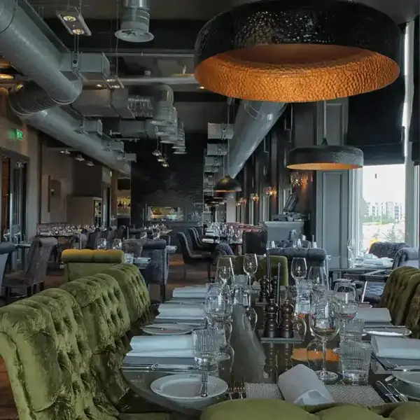 A dining room featuring a lengthy table adorned with green chairs.