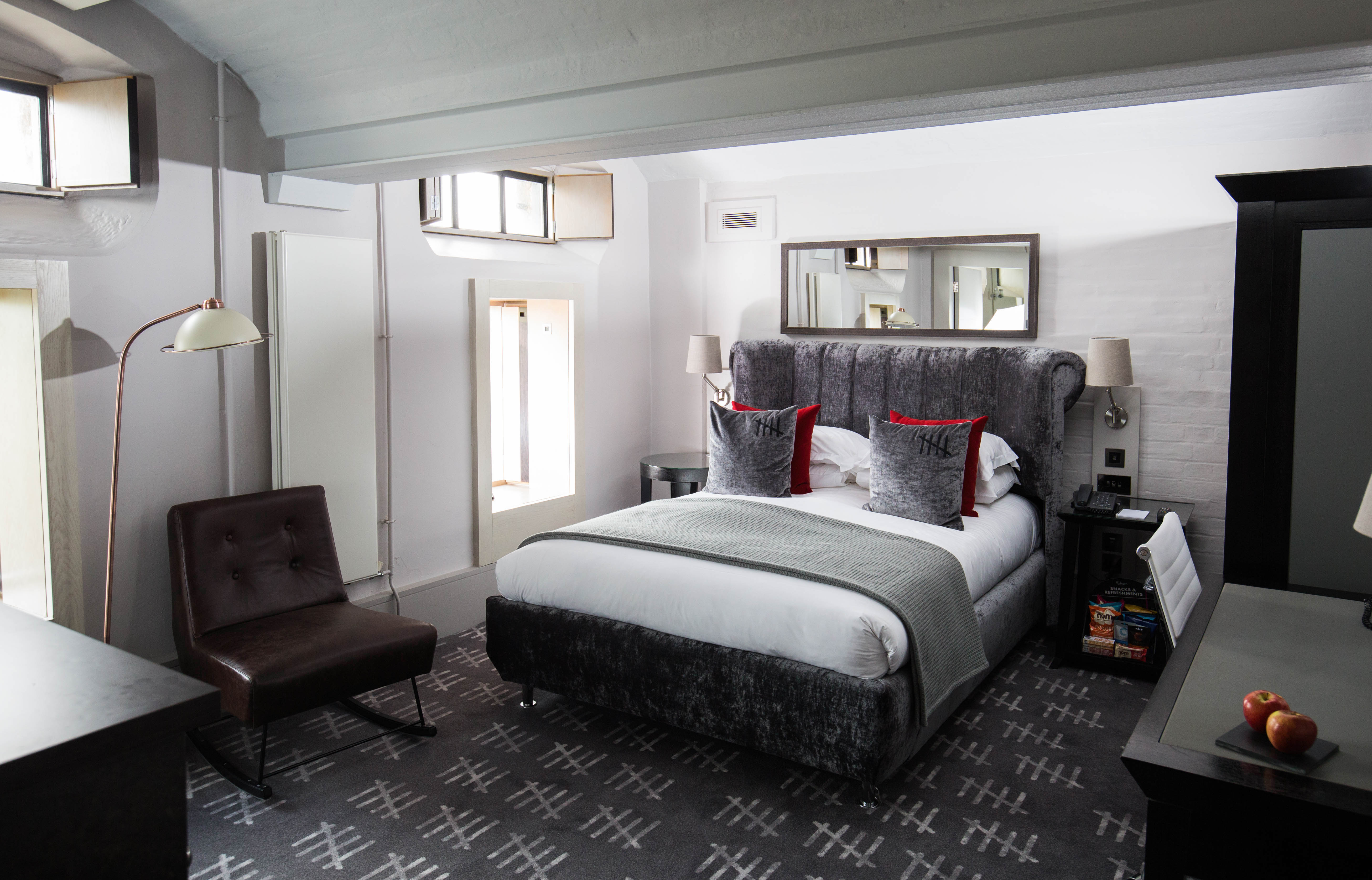 An elegantly furnished bedroom featuring a comfortable bed and a stylish chair.