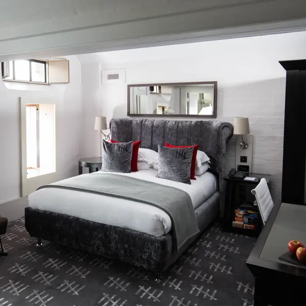 An elegantly furnished bedroom featuring a comfortable bed and a stylish chair.