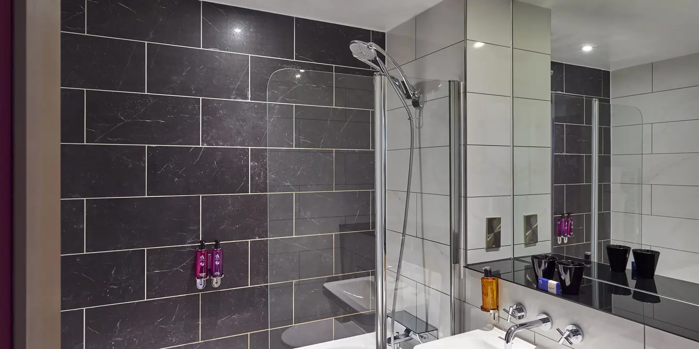 A bathroom featuring a sink, mirror, and bathtub.